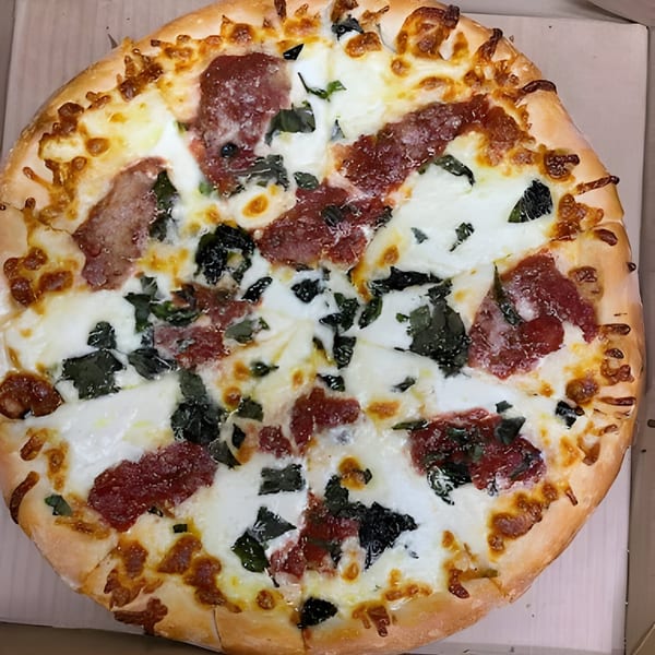 Bella Pizza's whole pizza with melted mozzarella, pepperoni, and spinach in a delivery box.